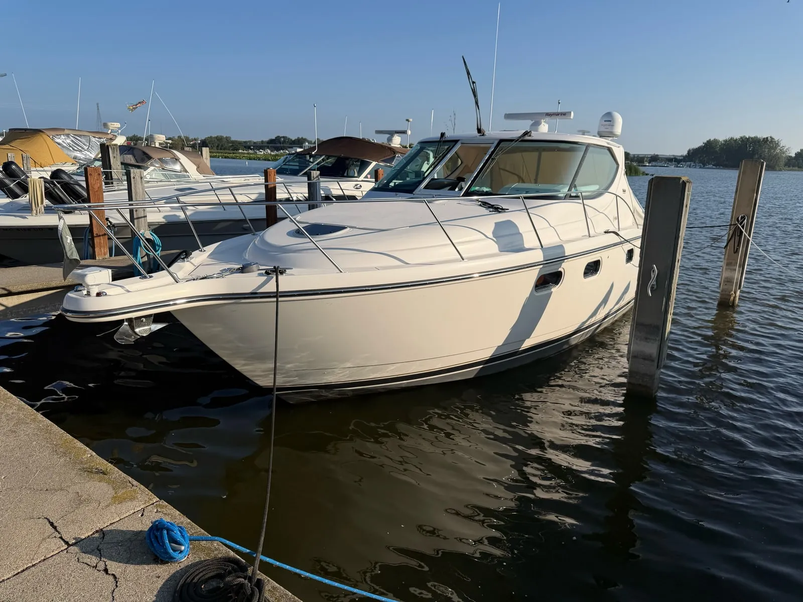 A cabin cruiser tied up at a west Michigan marina, its windscreen and cabin glass in view