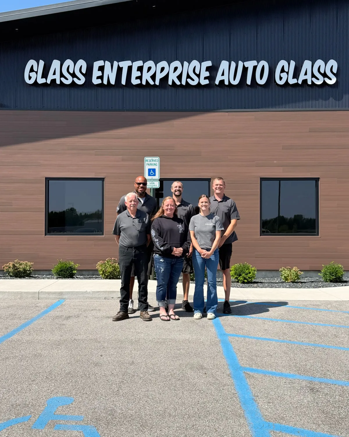 Six members of the Glass Enterprise Auto Glass crew outside the shop in Holland, Michigan